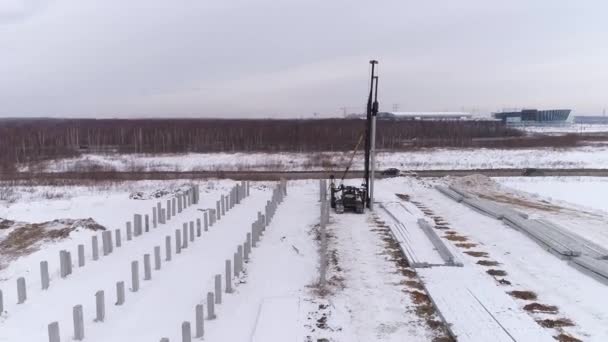 Drohnenaufnahme Einer Pfahlbohrmaschine Und Eines Arbeiters Auf Der Winterbaustelle Neben — Stockvideo