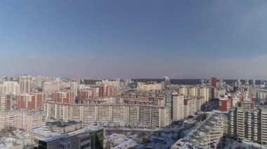 Oyun parkı ve çok katlı otoparkı olan iki yeni modern gökdelen manzarası. Kamera tipik Sovyet panellerindeki evlerin arasından geri uçuyor. Yakınlarda büyük şehirde araba trafiği olan bir otoyol var..