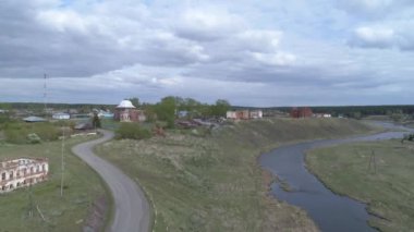 Eski köyün havadan görünüşü. Nehrin yüksek kıyısında eski harabe kırmızı tuğla binalar duruyor. Kilise restore ediliyor. Nehrin üzerine eski bir taş köprü inşa edildi. Yaz bulutlu günü