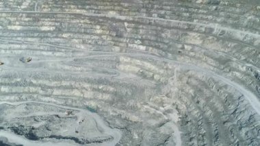 Dev asbest ocağındaki patlamanın havadan görüntüsü. Taş ocağının içinde kamyonlar için bir kazıcı ve serpentin yol var. Çekimin ortasında patlayıcılarla dolu bir alan var..