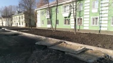 İki katlı bir sonbahar kasabasındaki yaya bulvarının yeniden inşasının insansız hava aracı görüntüsü. Çim ekme ve asfalt döşeme hazırlığı. İnşaat çalışmaları devam ediyor.