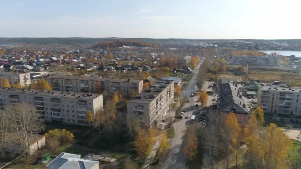 俄罗斯一个建筑和池塘都很低的城市的空中景观 三五层高的苏联老房子汽车沿着街道行驶 城里有许多黄叶的树 秋日阳光灿烂 — 图库视频影像