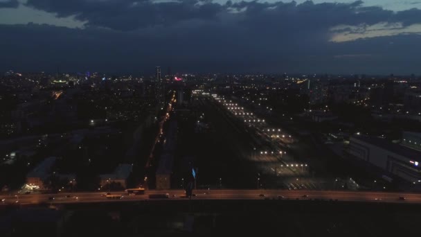 大きな夜の都市で車と貨物列車や橋と鉄道駅の空中ビュー 近くの高層住宅や低層住宅 工業地帯やオフィスビル 夏の夜 — ストック動画