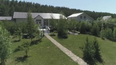 Kutlamalar ve düğünler için olan ziyafet evinin arka bahçesi. Avluda bir çim, bir patika, ağaçlar arasında bir salıncak ve bir bisiklet. Konuklar tatil beklentisiyle yürüyorlar..