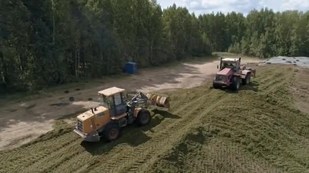 Drone View Tractors Tamp Silage Silo Trench Next Forest Field — Stockvideo
