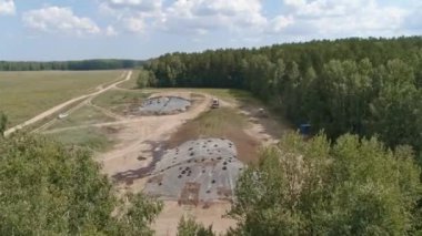 Traktörlerin hava görüntüsü, orman ve tarlanın yanındaki Silo Hendeği 'ndeki fidanı sıkıştırıyor. Hayvanlar için yem. Yaz güneşli bir gün