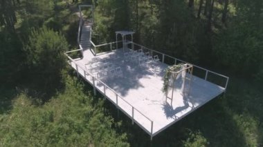 Nehrin yanındaki ormanın yanındaki rıhtımdaki düğün kemerinin havadan görünüşü. Düğün seremonisi. Yaz güneşli bir gün.