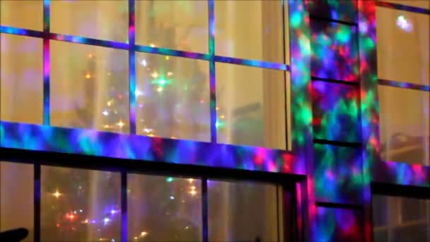 Blinklichtanlage an einem Fenster mit dem Weihnachtsbaum. — Stockvideo
