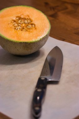 Tahtayı bıçakla kesen çekirdekli kavun.
