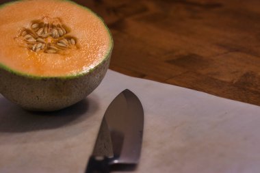 Tahtayı bıçakla kesen yarım kavun.