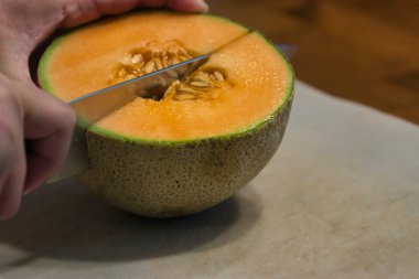 Kesme tahtasındaki yarım kavunu dörtte bir parçaya böldüm.