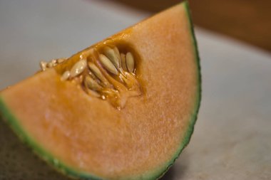 Kesme tahtasının üzerinde hala çekirdekleri olan kavun dilimi