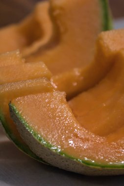 Tezgahta taze kavun doğrayan bir kadın.