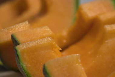 Tezgahta taze kavun doğrayan bir kadın.