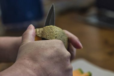 Tezgahta taze kavun doğrayan bir kadın.