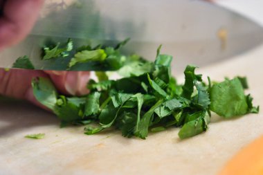 Kadınların elleri fesleğen yapraklarını dilimlenmiş kavunun yanında ince ince doğruyor.