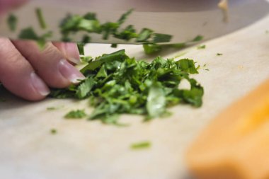 Kadınların elleri fesleğen yapraklarını dilimlenmiş kavunun yanında ince ince doğruyor.