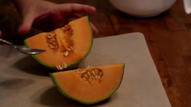 Tezgahta taze kavun doğrayan bir kadın.