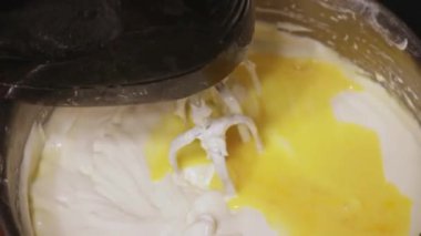 Parlak sarı yumurta gümüş kasede karışıyor.