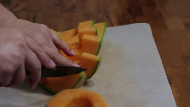 Femme hachant du cantaloup frais sur un comptoir — Video