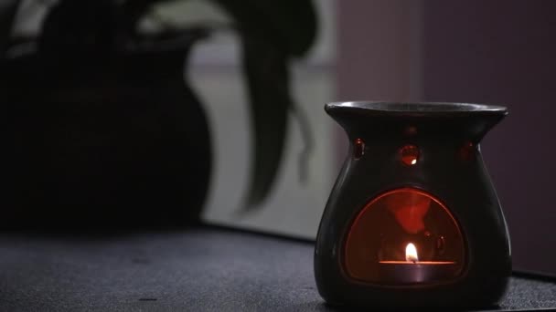 Malá svíčka zapálená uvnitř hořáku na esenciální olej — Stock video