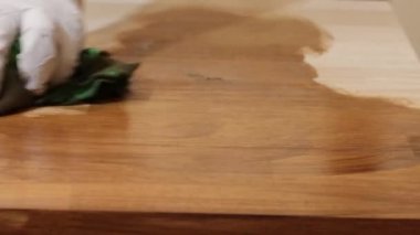 Profesyonel, çiğ ahşabı fırçalamak için bez kullanıyor.