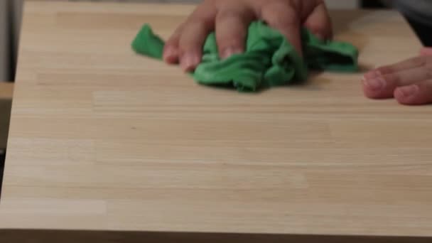 Womans hands cleaning dust off of a wooden surface — Stock Video