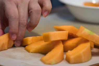 Keskin bir bıçak, kavun parçalarını kesiyor.