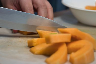 Keskin bir bıçak, kavun parçalarını kesiyor.