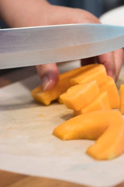 Keskin bir bıçak, kavun parçalarını kesiyor.