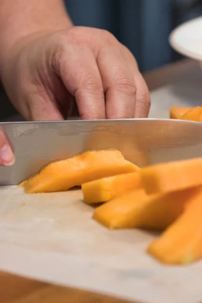 Cuchillo afilado que corta a través de una pila de trozos de melón — Foto de Stock