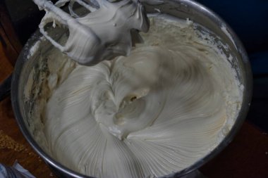 Çırpılmış krema kaplı bir elektrikli mikser.