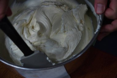 Kadın hamuru katlamak için spatula kullanıyor.