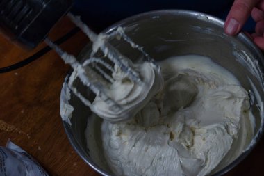 Çırpılmış krema kaplı bir elektrikli mikser.