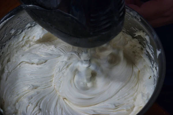 an electric mixer swirling a bowl of ingredince into a batter