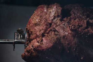 Domuz rostosu döner ve bir rostoya yağ damlatır.