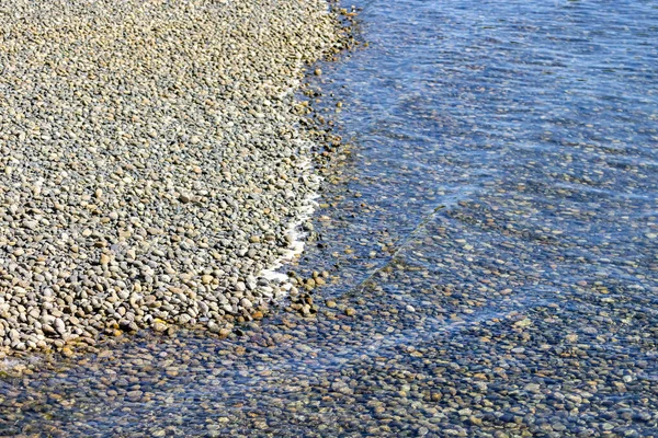 Felsen unter dem flachen Wasser am Strand — Stockfoto