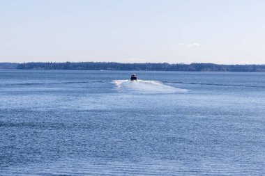 Uzaktaki tekne ufka doğru hızla ilerliyor.