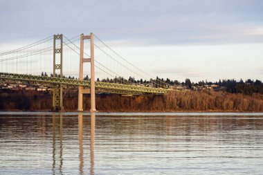 Günbatımında yansıtıcı su üzerinde dar köprü