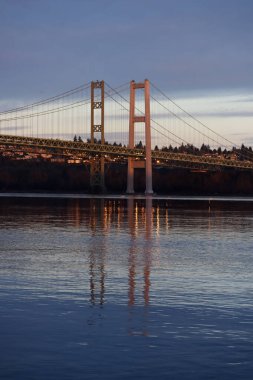 Sakin su dar köprüyü ve hava kararınca gökyüzünü yansıtıyor.