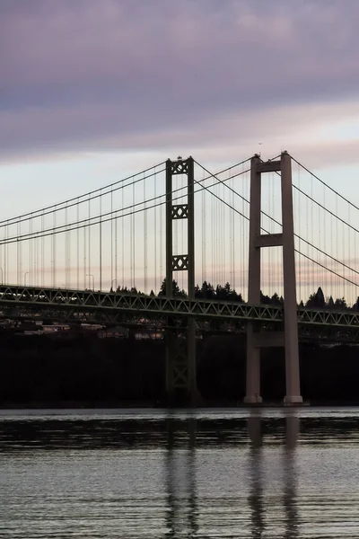 Міст Tacoma Narrows розтягнувся над звуком у сутінках. — стокове фото