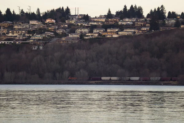 Tren en el borde del suburbio y frente al mar al atardecer — Foto de Stock