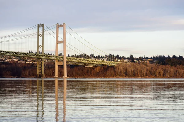 Günbatımında yansıtıcı su üzerinde dar köprü