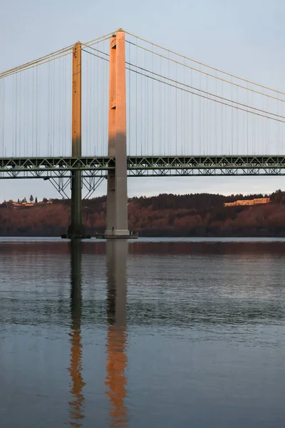 Gyllene inställning ljus på smala bron över lugnt vatten — Stockfoto