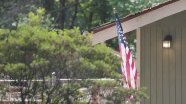 Kırsal Amerika 'da bir evin önünde Amerikan bayrağı dalgalanıyor.