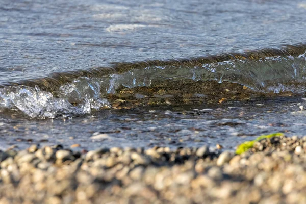 Kleine klare Welle kracht auf einen Strand — Stockfoto