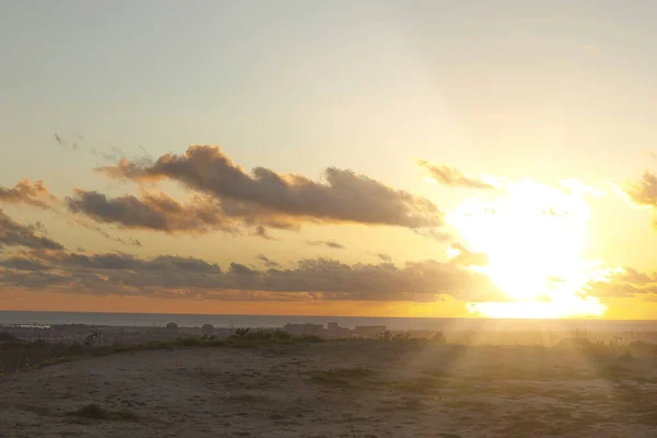 Luz ao pôr do sol sobre a praia com nuvens — Fotografia de Stock