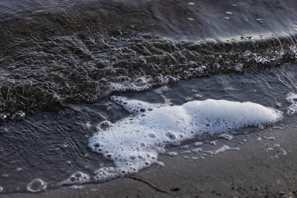 Sahilde küçük bir dalganın beyaz köpüğü. — Stok fotoğraf