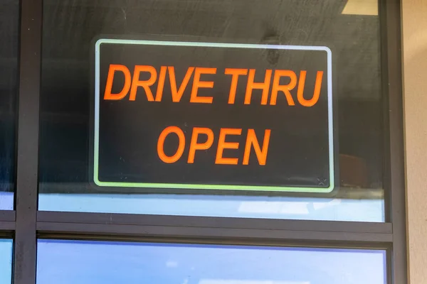 Red sign reads drive thru open in restaurant window — Stock Photo, Image