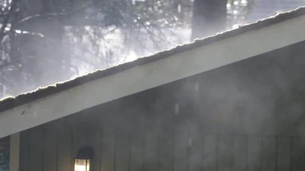 Sunlight through swirling fog and rain on roof — Stock Video